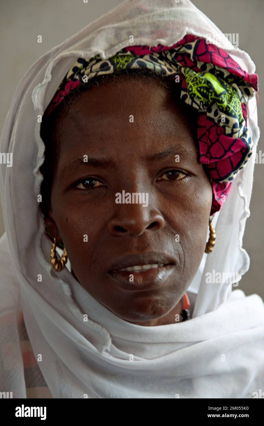 Gesichter Afrikas, Afrikanerin, Bafata, Guinea-Bissau - ängstliche Ausdrucksform; schönes Kopfkleid; goldene Ohrringe; Stockfoto