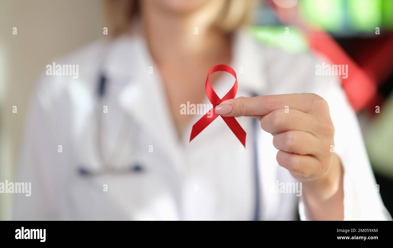 Der Arzt zeigt das rote Band als Symbol des Welt-Aids-Tages. Stockfoto
