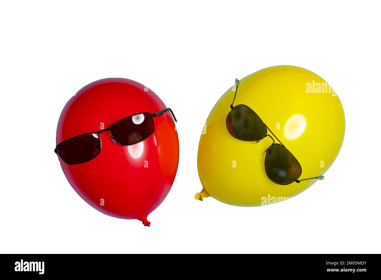 Ein roter und ein gelber Ballon mit Sonnenbrille auf einer transparenten Oberfläche Stockfoto