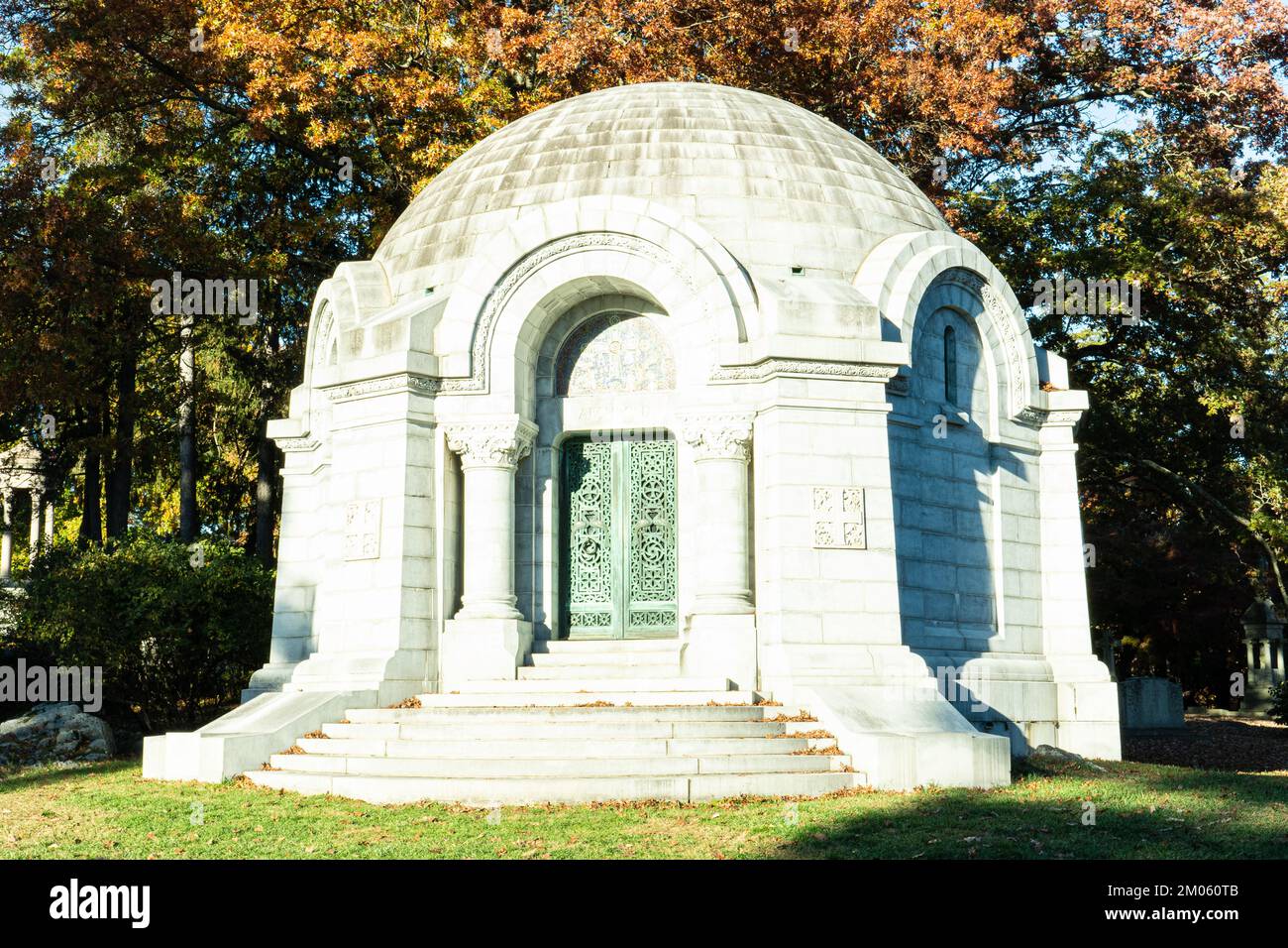 Vorderansicht des steinernen Mausoleums, das von den Sonnenstrahlen der Herbstsonne auf dem Friedhof in Sleepy Hollow, New York, beleuchtet wird. Stockfoto