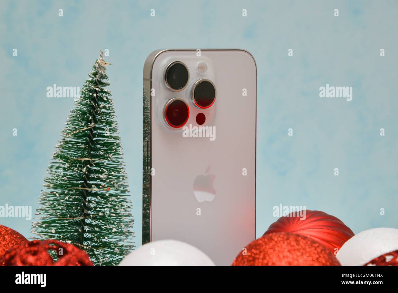 Riga/Lettland - 4. Dezember 2022: Neues modernes Telefon - iPhone 14 pro unter den glitzernden Weihnachtsdekorationen auf schwarzem Hintergrund. Weihnachtsgeschenk Conce Stockfoto