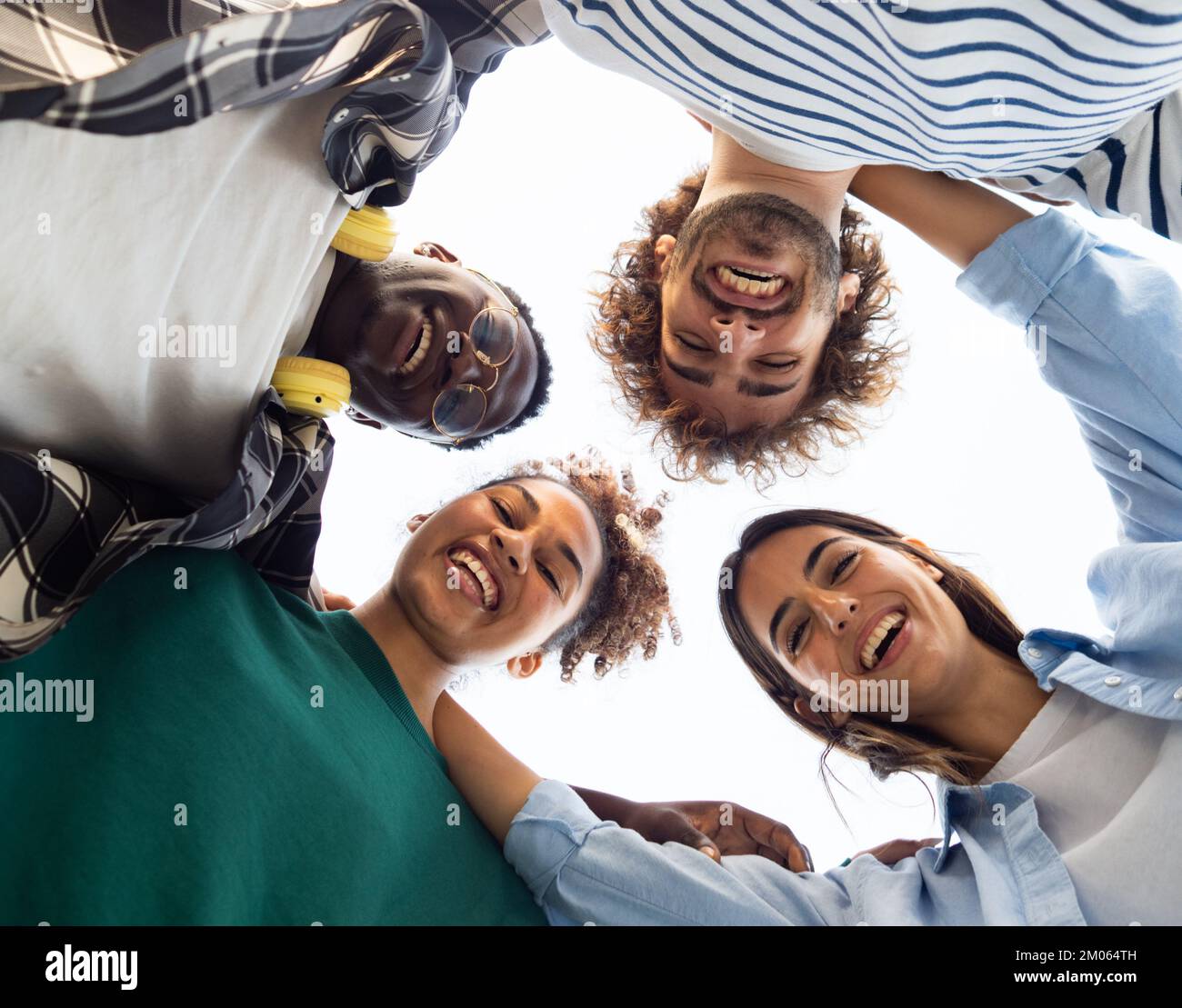Ein Kreis von Smiley-Gesichtern von unten lustige multiethnische Freunde. Freundschaft und Vielfalt Stockfoto