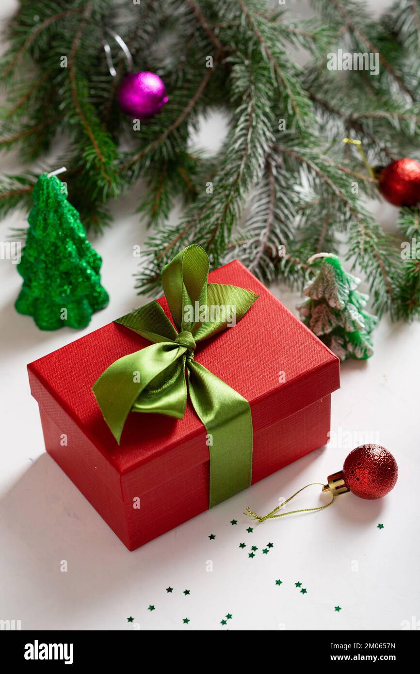 Rote Weihnachtsbox mit grünen Schleifen- und Tannenzweigen Stockfoto