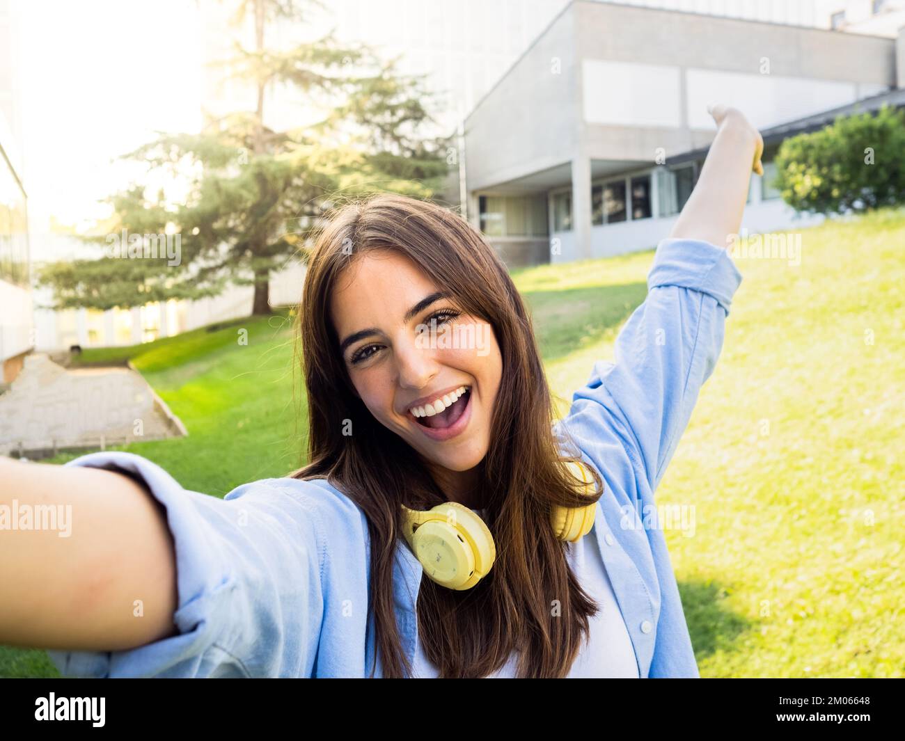 Selfie-Perspektive einer jungen lächelnden Studentenfrau auf dem Campus Stockfoto