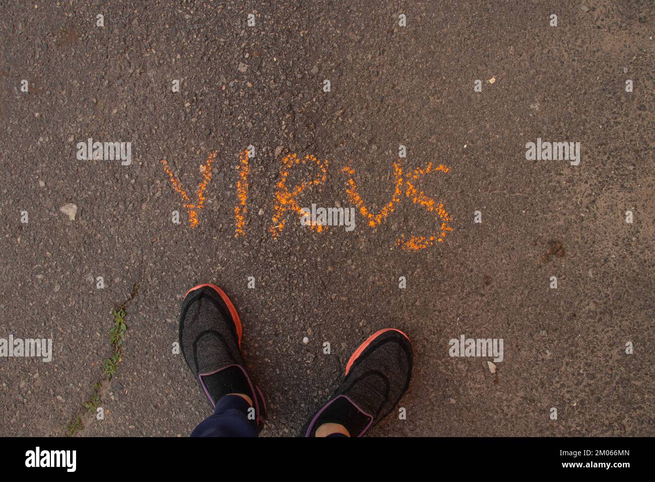 Das Wort Virus wird in englischer Kreide auf dem Asphalt geschrieben Stockfoto