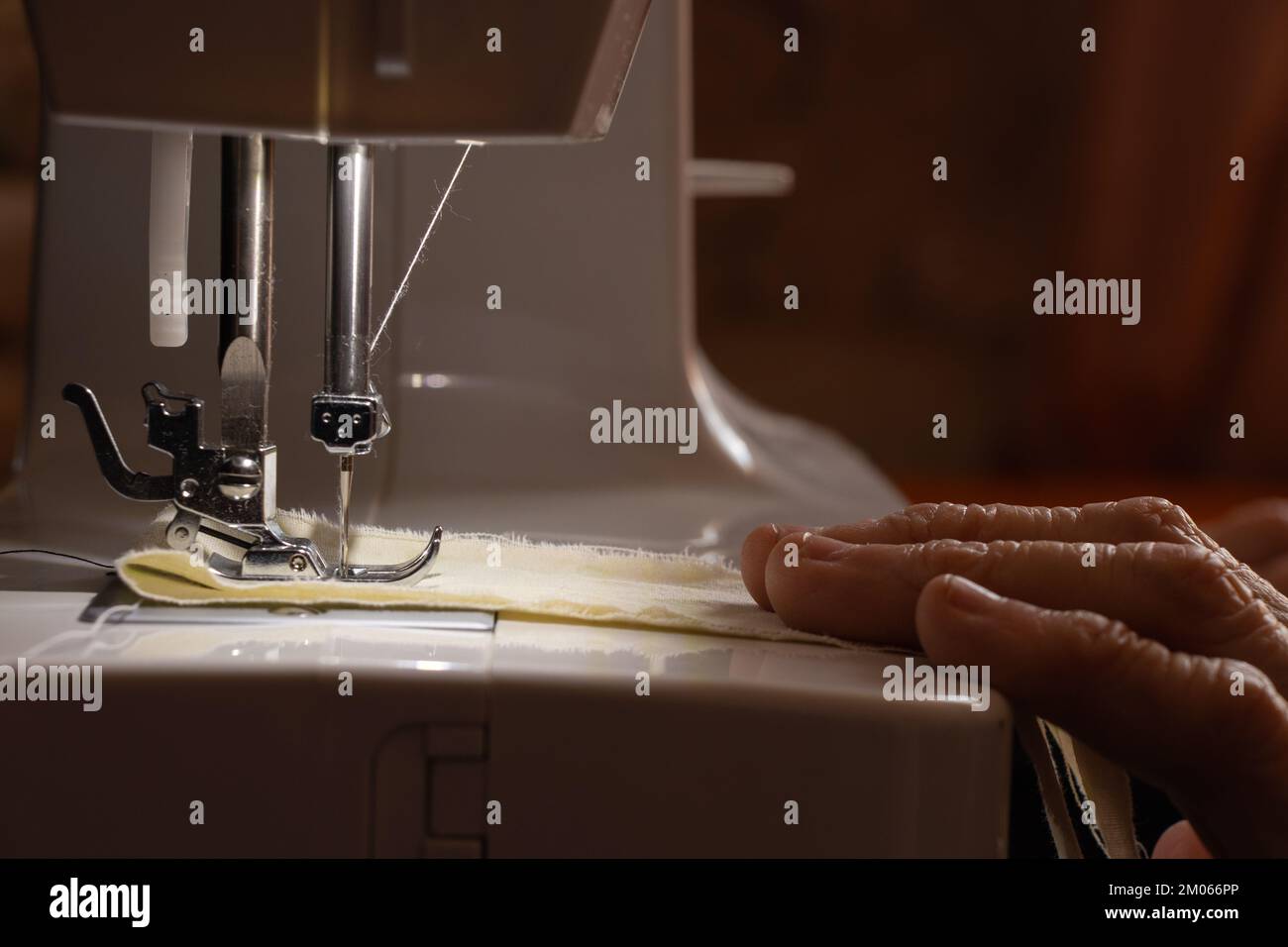 Nähmaschine und die Hand der alten Großmutter Stockfoto