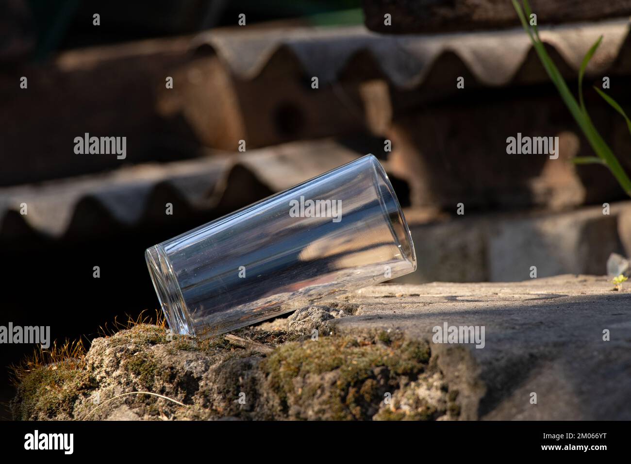 Ein leerer durchsichtiger Glasbecher steht auf dem Boden Stockfoto