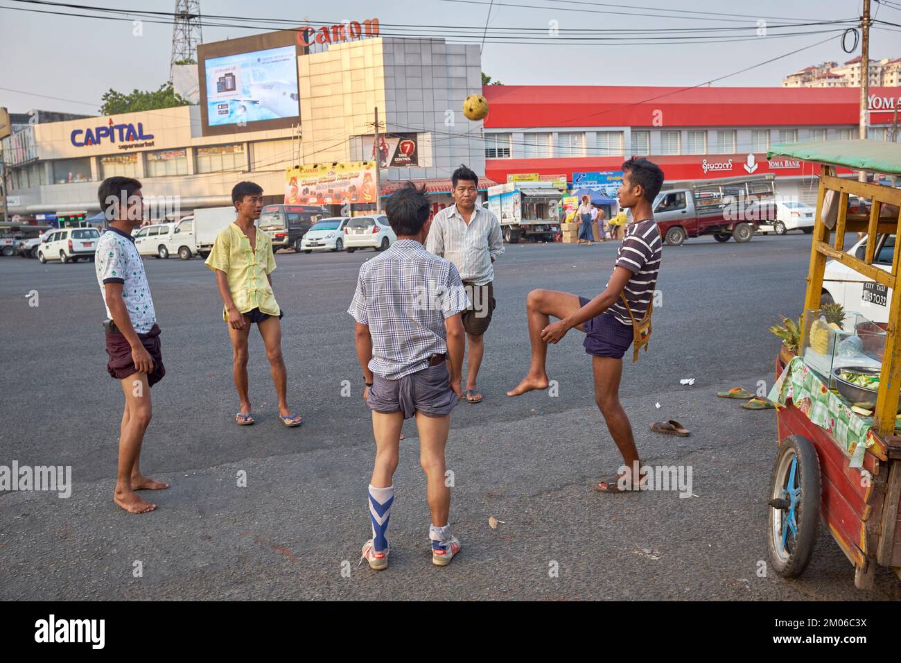 Junge Männer spielen Straßenfußball in Yangon Myanmar Stockfoto