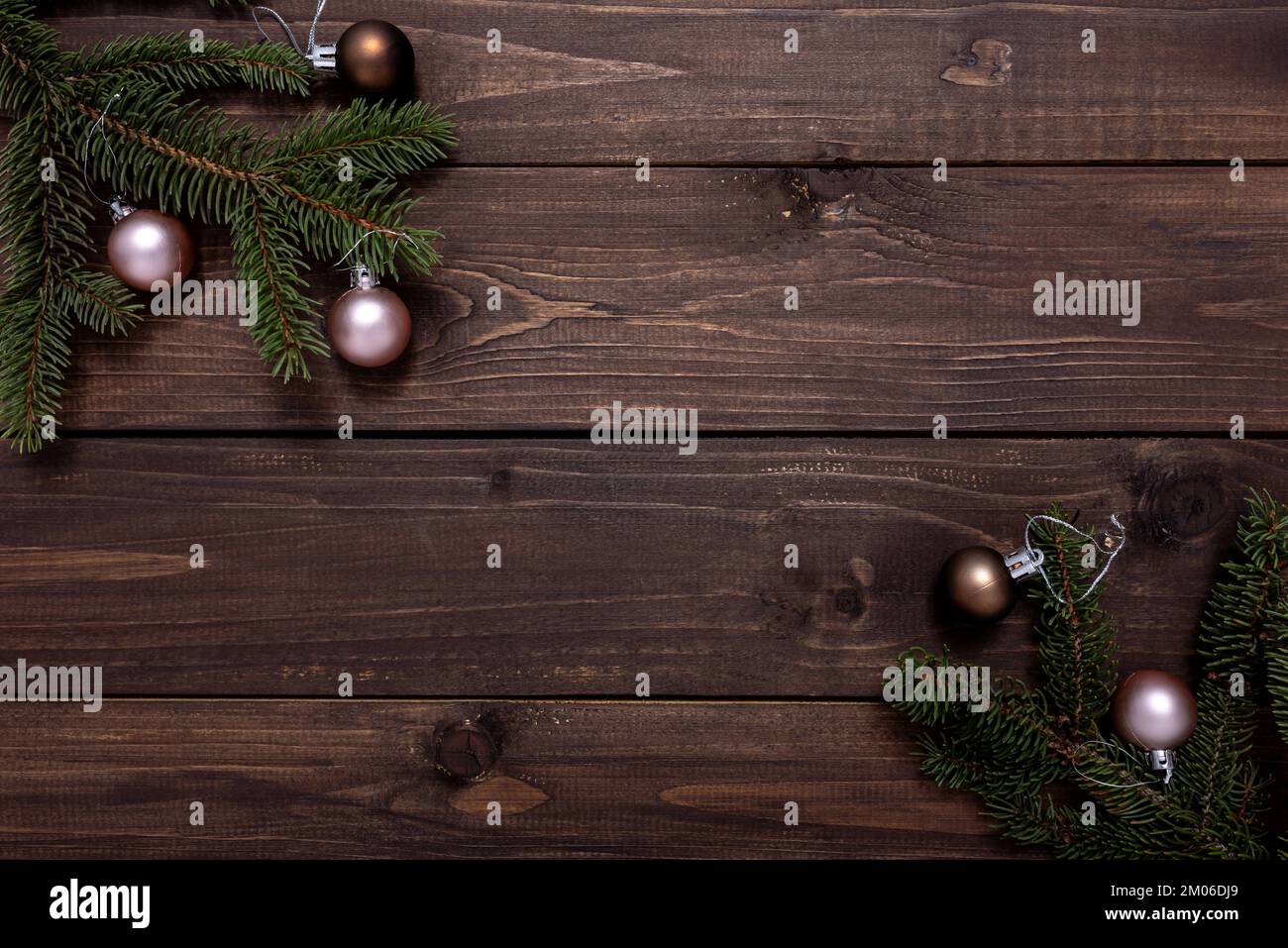 Weihnachtsrahmen aus Tannenzweigen und Weihnachtskugeln auf einem Holztisch mit Platz für Text. Weihnachtskonzept und Neujahrskonzept. Stockfoto