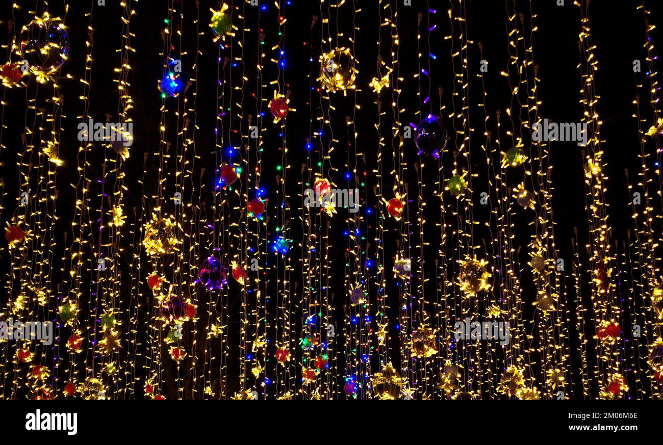 Farbenfrohe Weihnachtsdekorationen, Girlanden am Nachthimmel Stockfoto