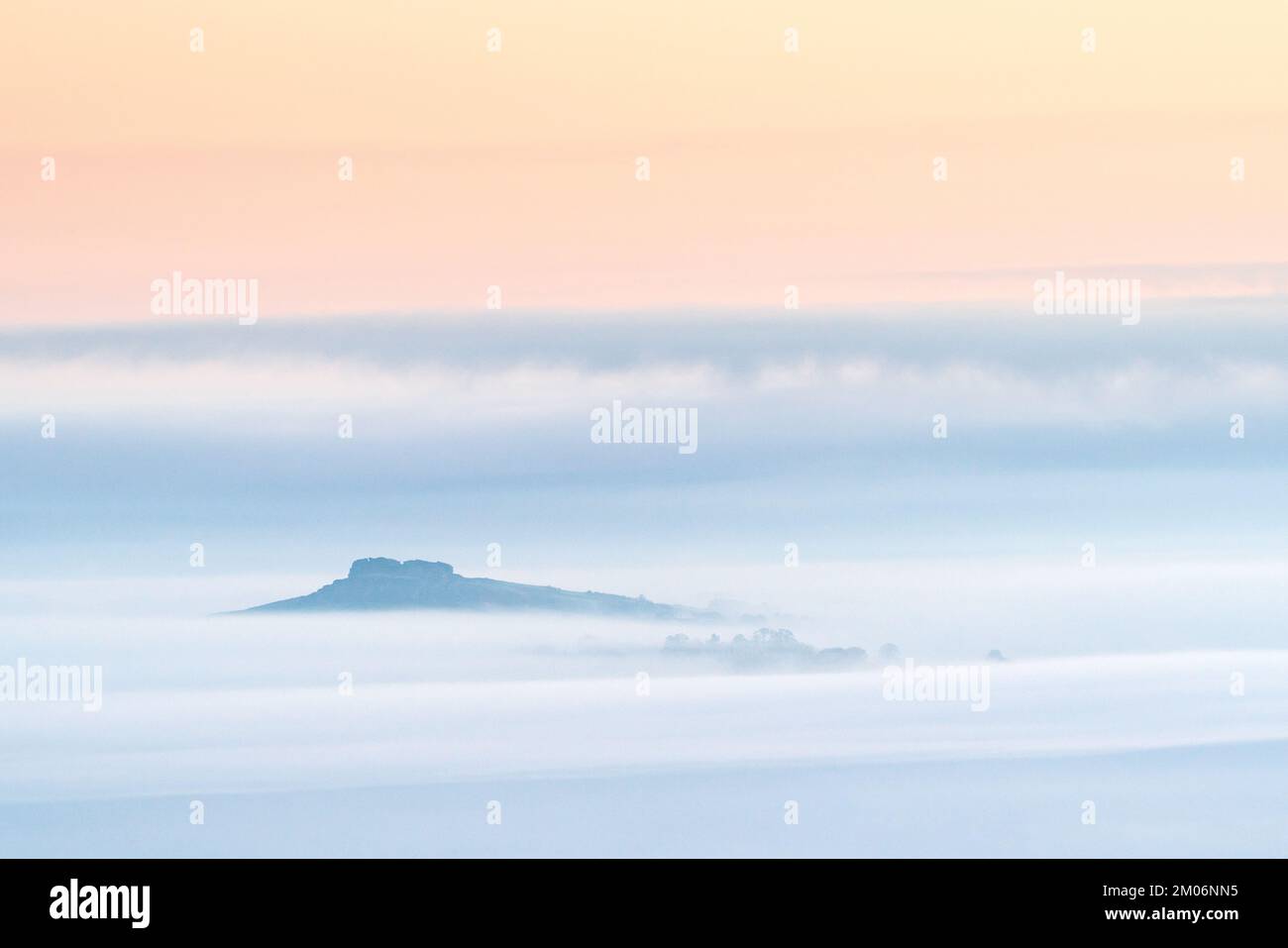 Almscliffe Crag ist über einer Nebeldecke sichtbar, die die gesamte umliegende Landschaft während einer Herbsttemperatur umgibt. Stockfoto