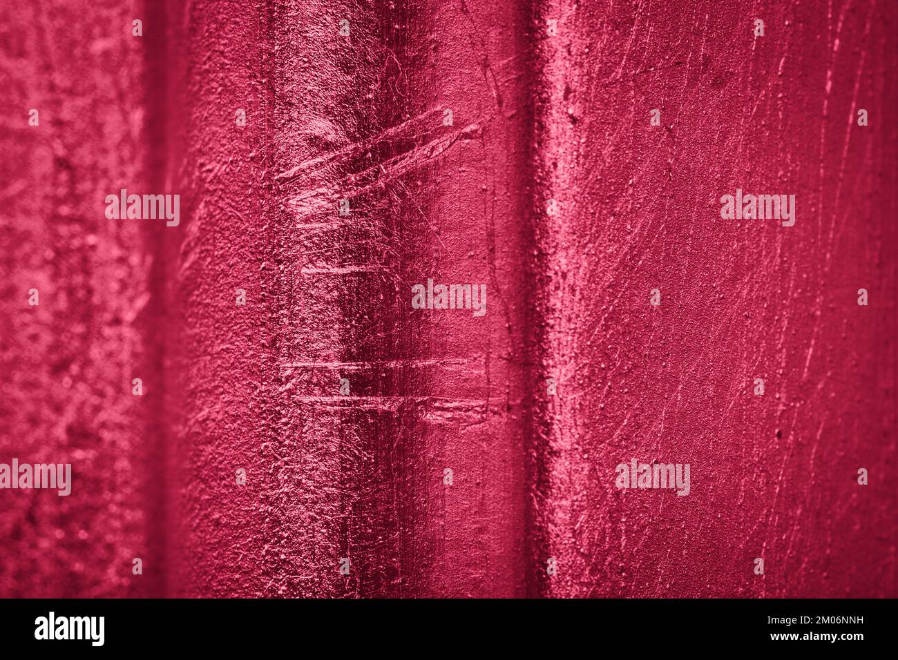 Reliefwand in Metallic-Viva-Magenta. Roter abstrakter Hintergrund für die Farbe des Jahres 2023 Stockfoto