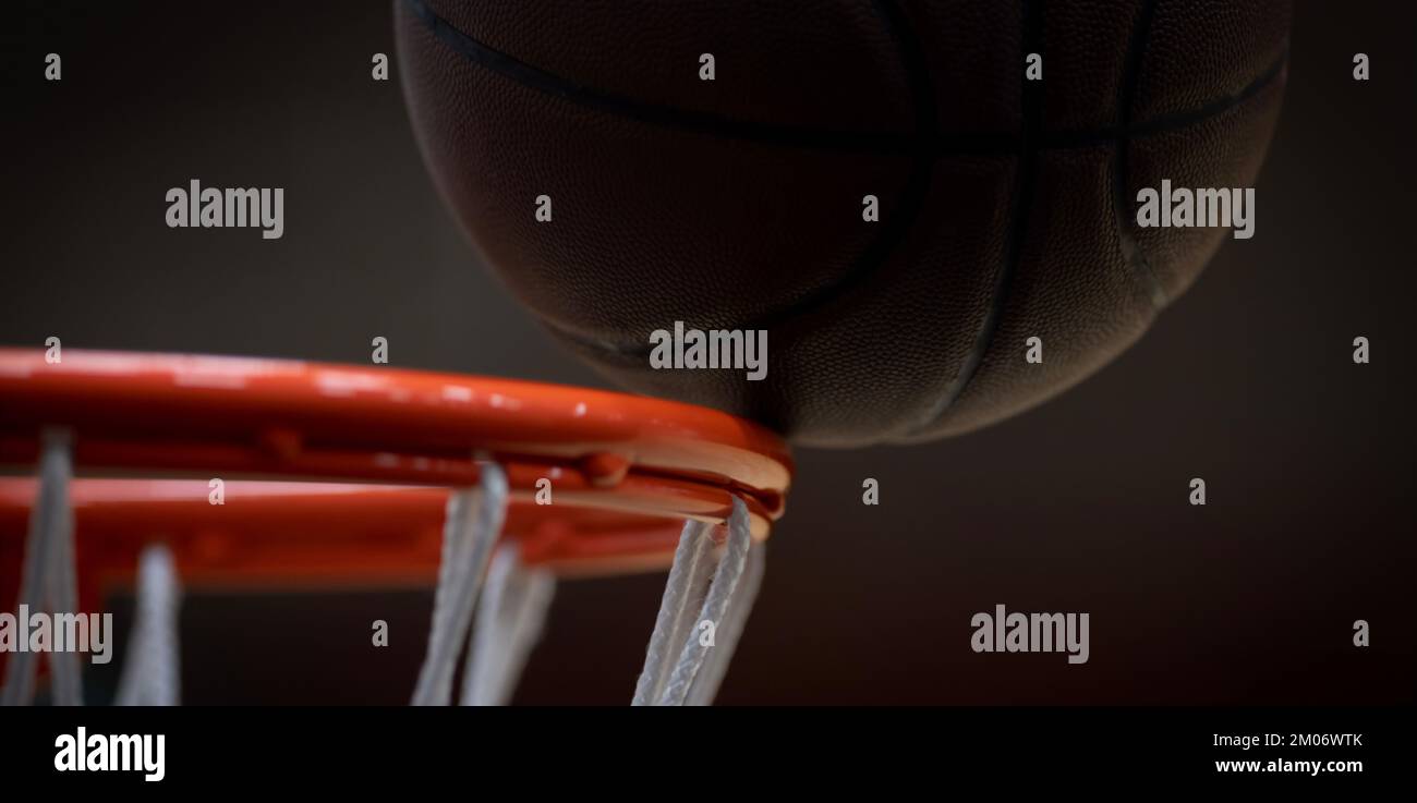 Brauner Basketballball auf orangefarbenem Reifen. Horizontales Sportposter, Grußkarten, Kopfzeilen, Website Stockfoto
