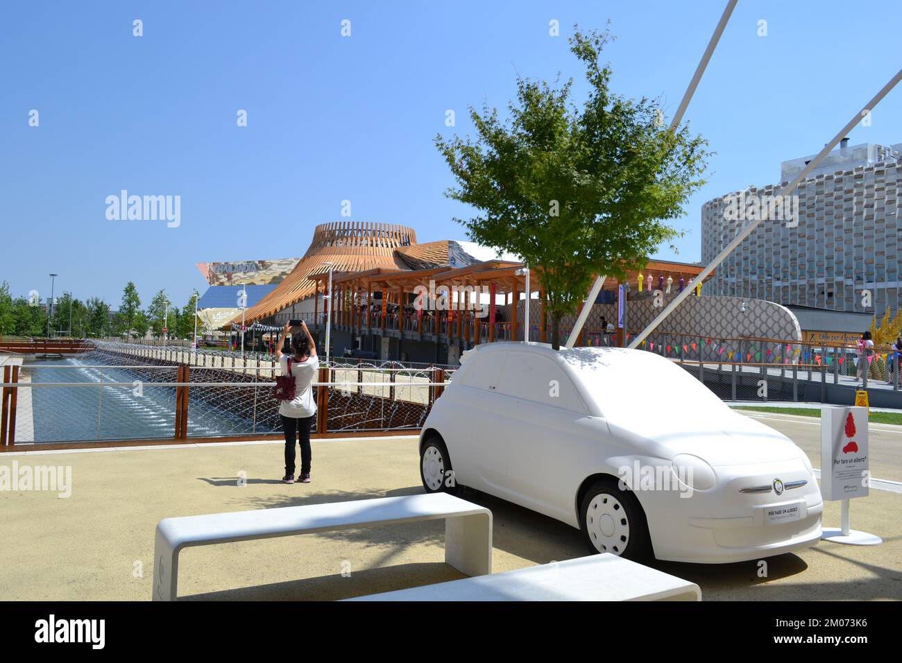 FIAT-Baum-Auto. Nahaufnahme des Modells des berühmten Fiat 500, das an einem sonnigen Tag auf der EXPO Milano 2015 einen 12 Meter hohen Birnenbaum beherbergt. Stockfoto