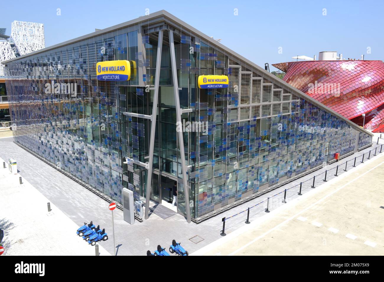 Panoramablick auf den New Holland Agriculture Pavillon auf der EXPO Milano 2015, erbaut als riesige dreieckige Glasbox zur Nutzung von Solarenergie. Stockfoto