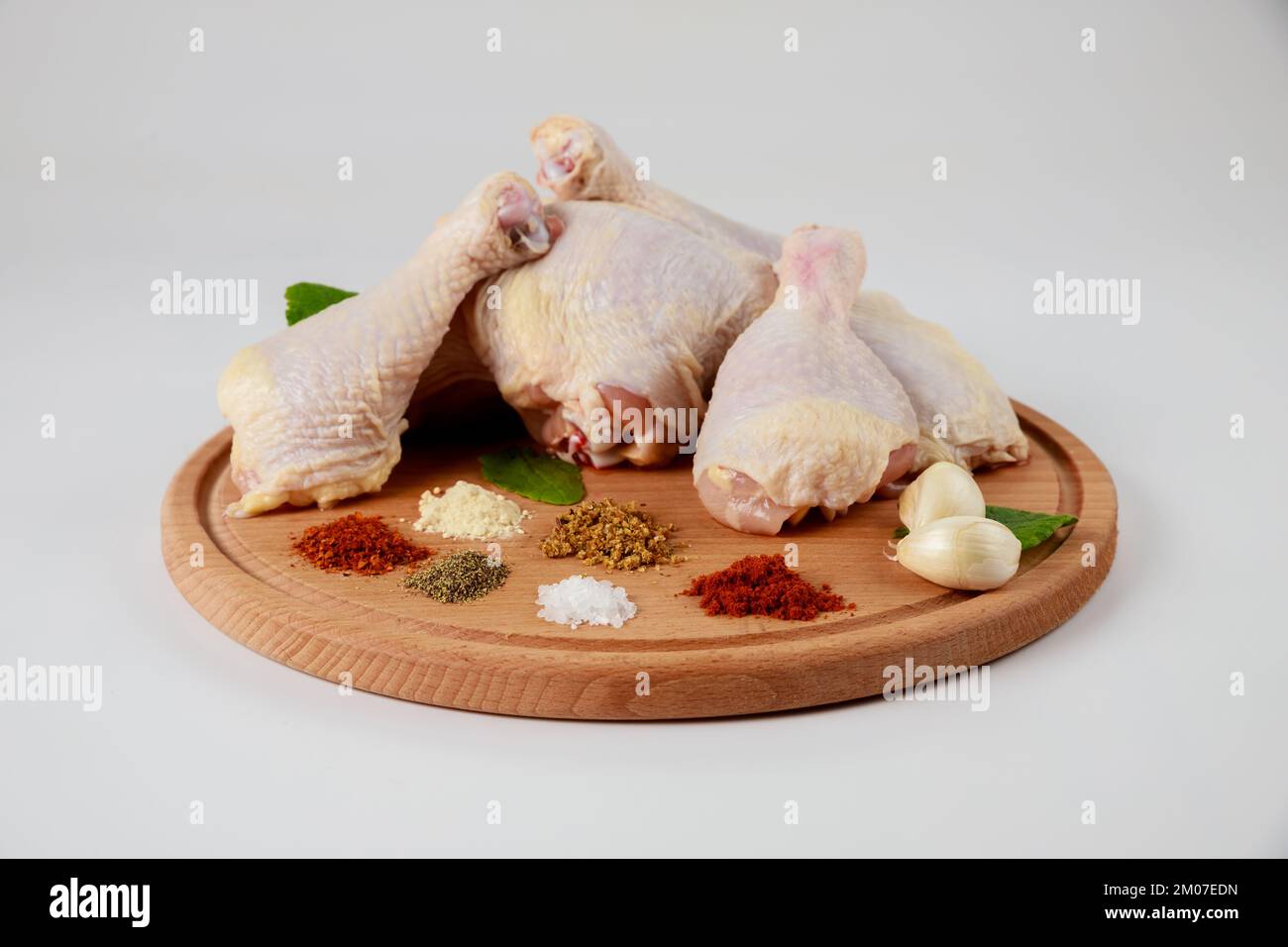 Bereiten Sie rohe Hähnchenschenkel mit Gewürzen zu, um ein köstliches Gericht zuzubereiten. Stockfoto