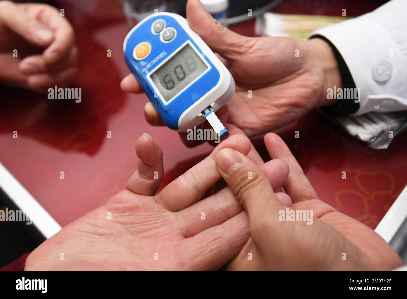 GUIYANG, CHINA - 5. DEZEMBER 2022 - Ein Hausarzt überprüft den Blutzucker in einem Altersheim in Guiyang, Provinz Guizhou, China, 5. Dezember 2022. Stockfoto