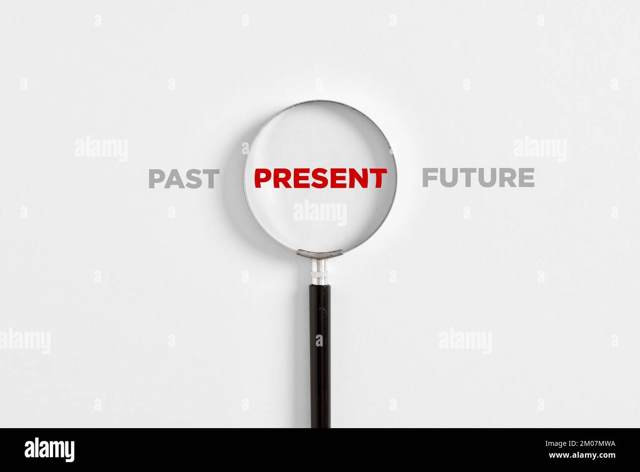 Konzentration auf die aktuelle Situation, positives Denken und Denkmuster. Lupe auf das Wort "präsent" mit den Worten "Vergangenheit" und "Zukunft". Stockfoto
