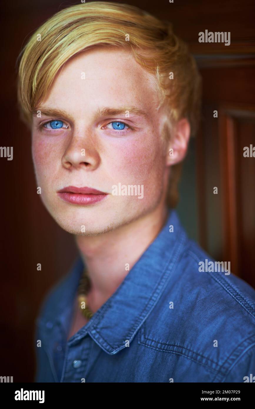 Durchstechende blaue Augen. Rücksichtsvoller und attraktiver junger blonder Kerl mit sehr blauen Augen. Stockfoto