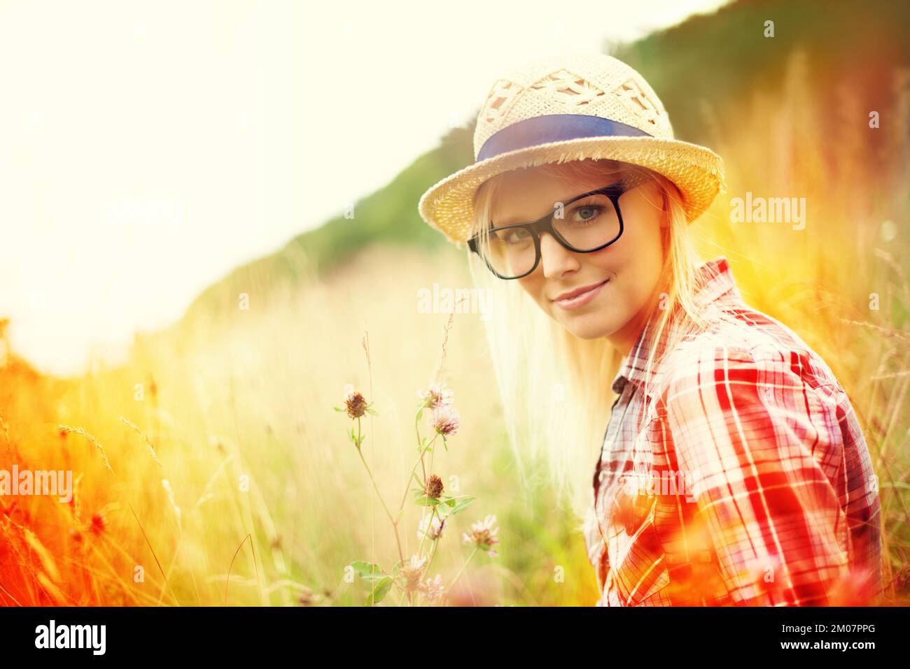 Ich muss dir etwas zeigen. Wunderschöner junger Hipster auf einem Feld - Lomo-Fotografie. Stockfoto