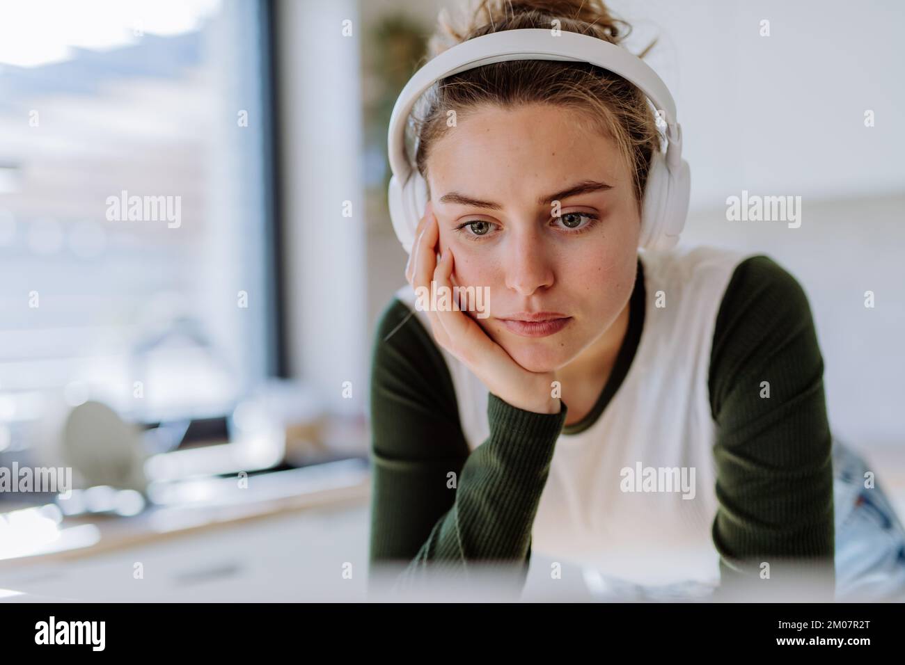 Porträt einer jungen Frau, die Hausaufgaben in ihrer Küche hat. Stockfoto