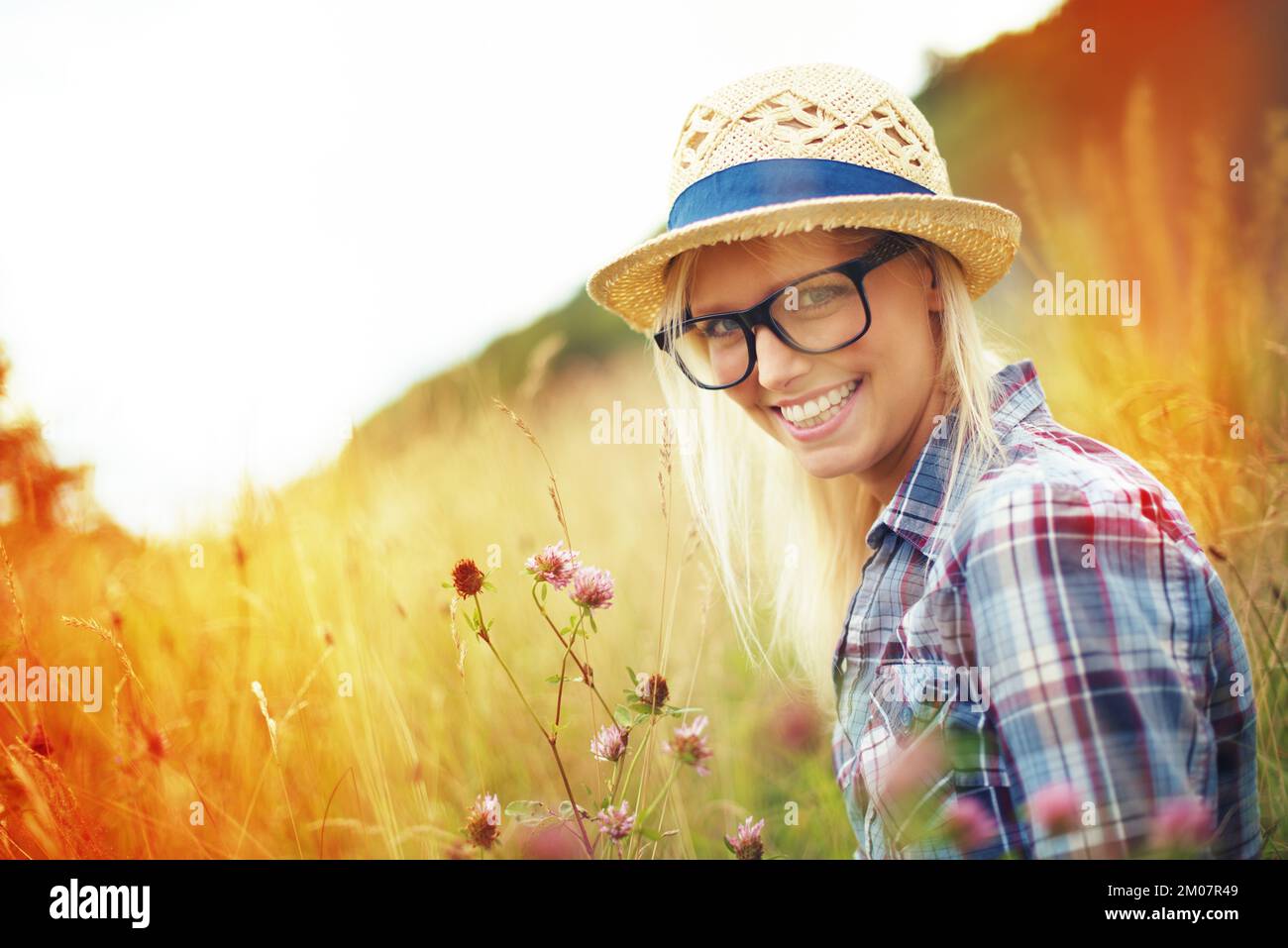 Das ist ihr glücklicher Ort. Wunderschöner junger Hipster auf einem Feld - Lomo-Fotografie. Stockfoto