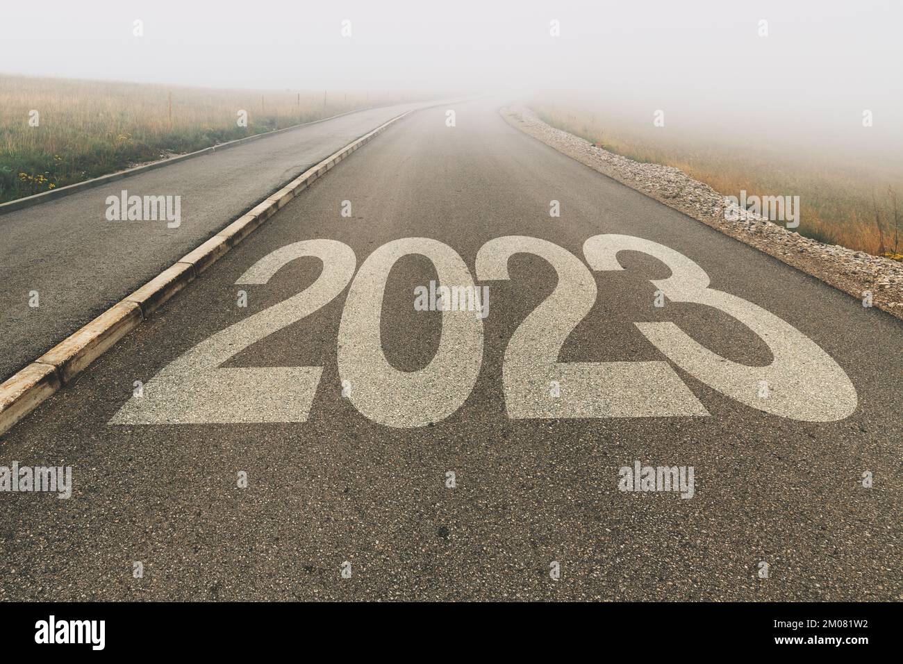 2023 Unsicherheit im neuen Jahr, Zahl auf Asphaltstraße bis unendlich verschwindet in nebeliger, schwindender Perspektive, selektiver Fokus Stockfoto