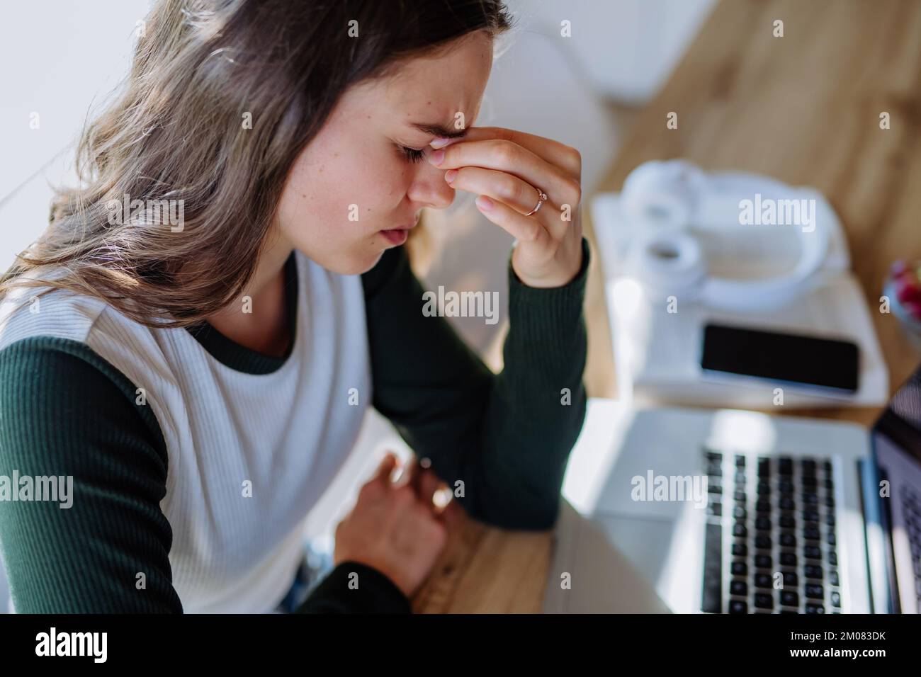 Porträt einer müden Frau mit Laptop, Hausaufgaben-Konzept. Stockfoto