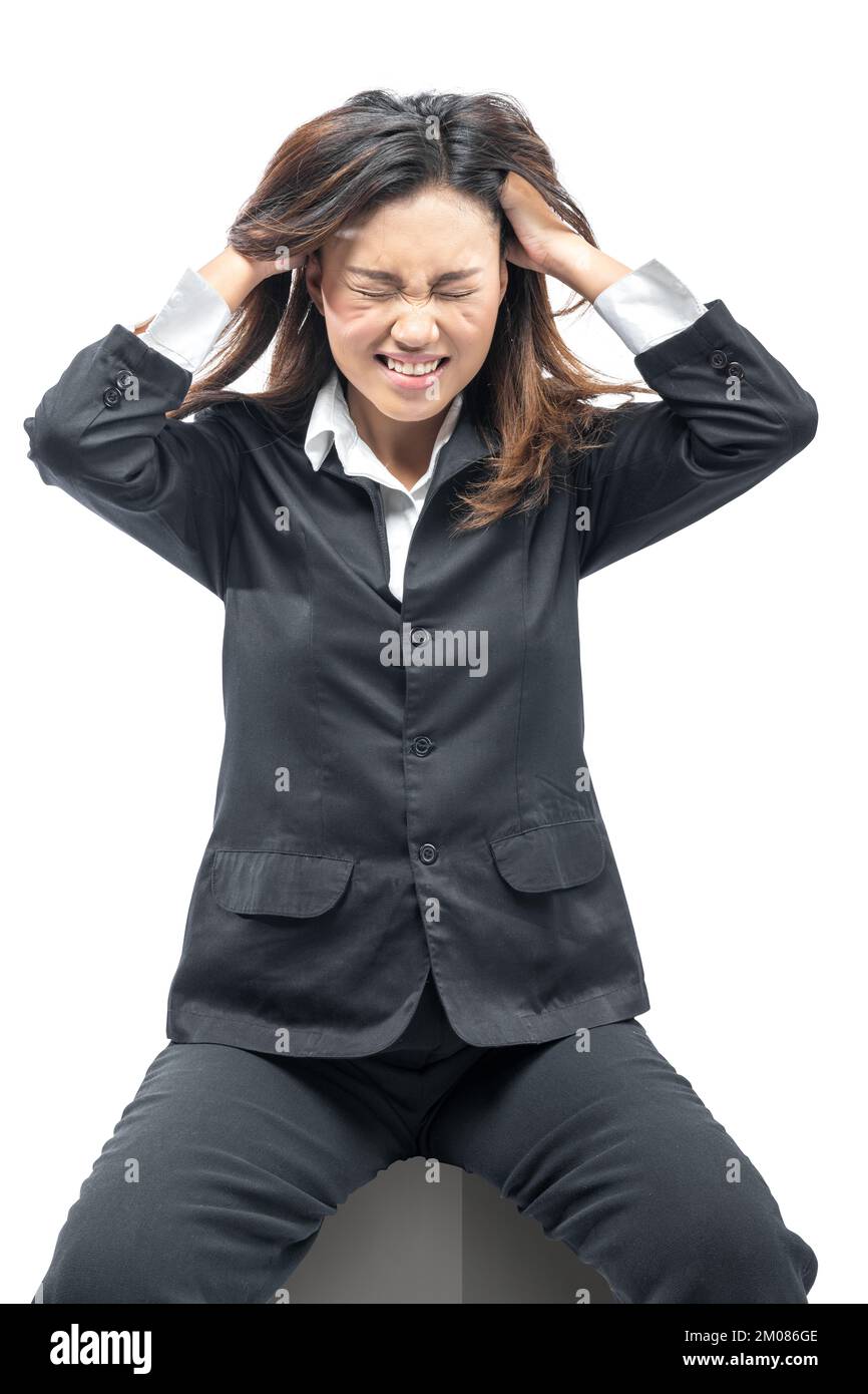 Asiatische Geschäftsfrau, die mit frustriertem Ausdruck auf weißem Hintergrund sitzt Stockfoto