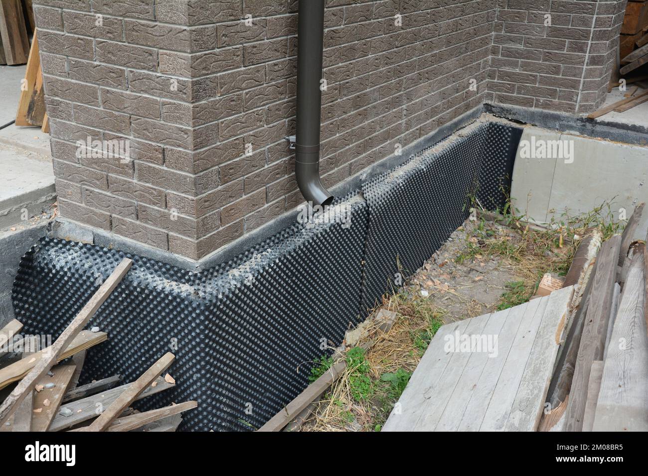 Abdichtung des Untergeschosses des Hausfundamentes, Feuchtigkeitsabdichtung mit starrer Dämmung. Einbau einer vertieften Wasserdichtungsmembran an den äusseren Basemen Stockfoto