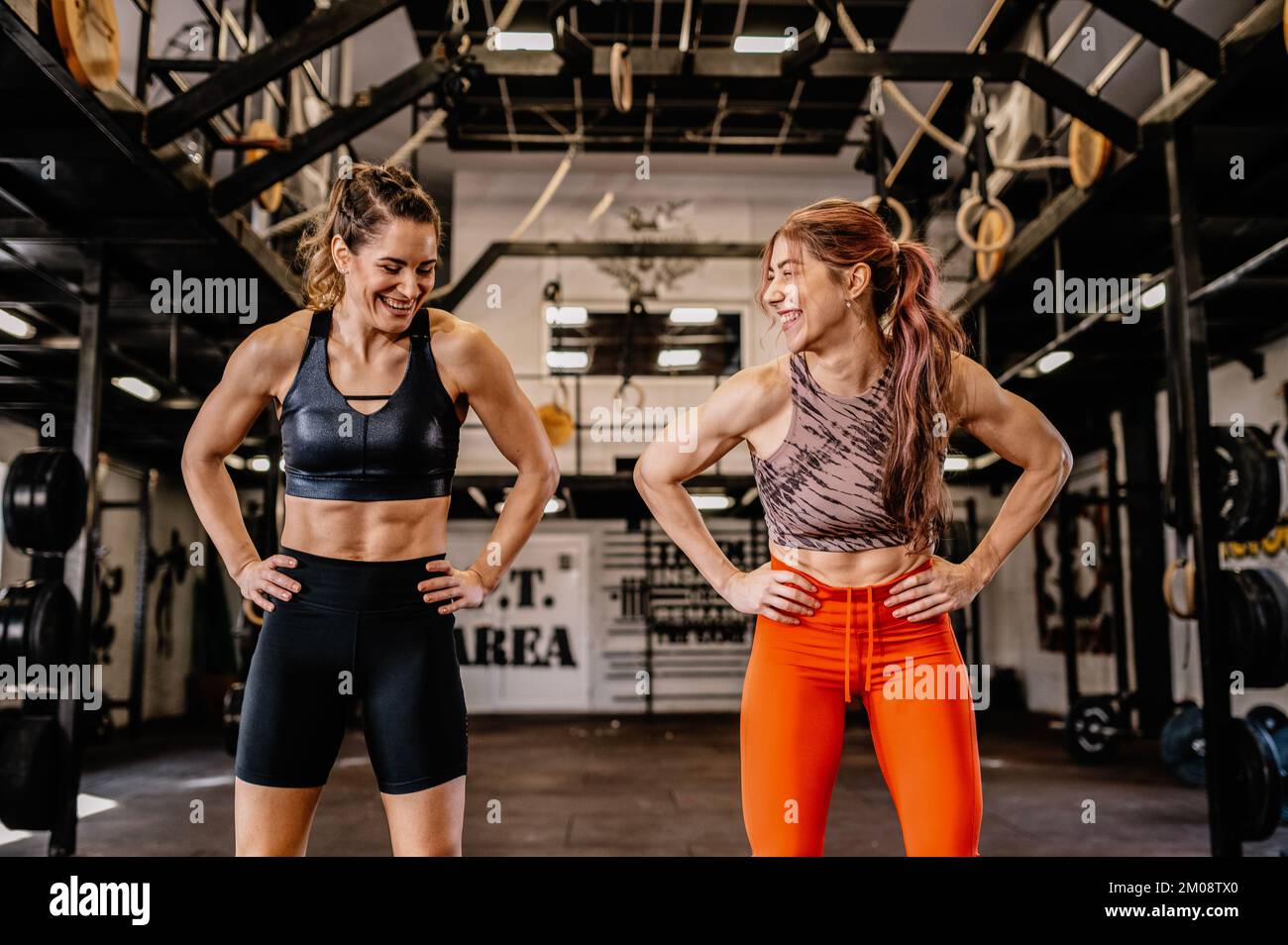Zwei junge Mädchen stehen im Fitnessstudio und lachen. Stockfoto