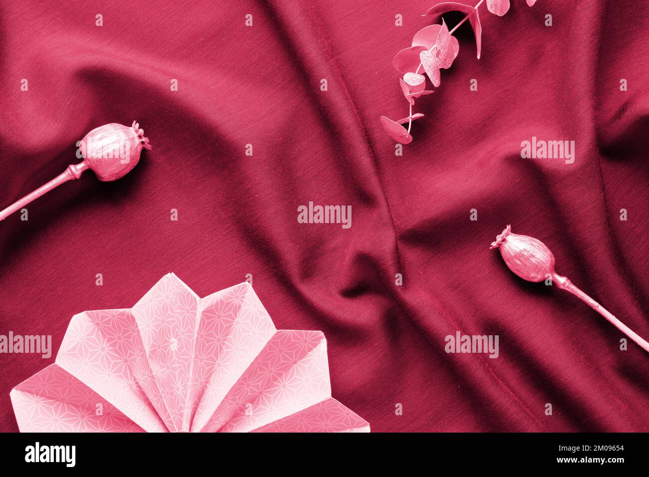 Viva Magenta-Farbe des Jahres 2023. Dunkelroter Hintergrund. Monochromatische flache Unterlage mit Disco-Kugeln auf rotem Seidenstoff-Hintergrund. Stockfoto