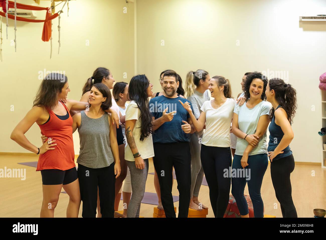 Eine Gruppe von Studenten und Yoga-Lehrern, die am Ende des Kurses miteinander reden Stockfoto