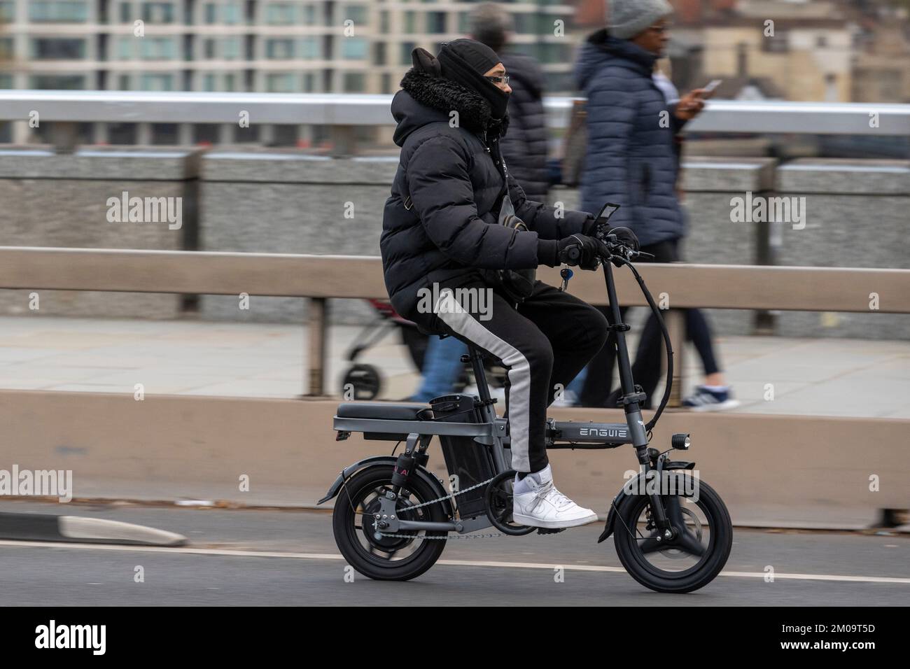 Ein Mann pendelt mit einem E-Bike über die London Bridge, London, Großbritannien. 18. November 2022 Stockfoto