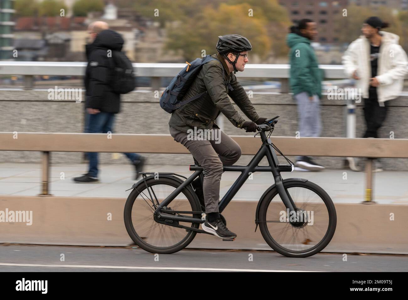 Ein Mann pendelt mit einem E-Bike über die London Bridge, London, Großbritannien. 18. November 2022 Stockfoto