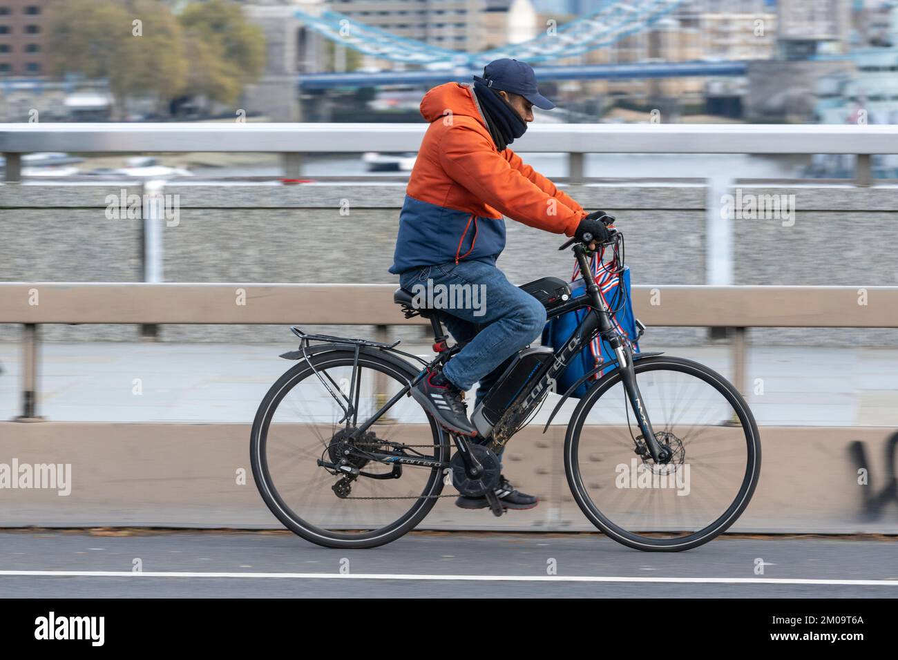 Ein Mann pendelt mit einem E-Bike über die London Bridge, London, Großbritannien. 17. November 2022 Stockfoto