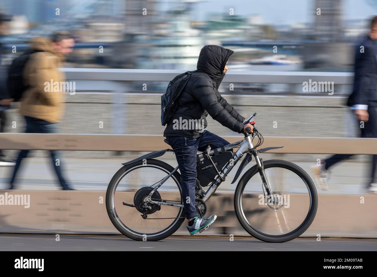 Ein Mann pendelt mit einem E-Bike über die London Bridge, London, Großbritannien. 17. November 2022 Stockfoto