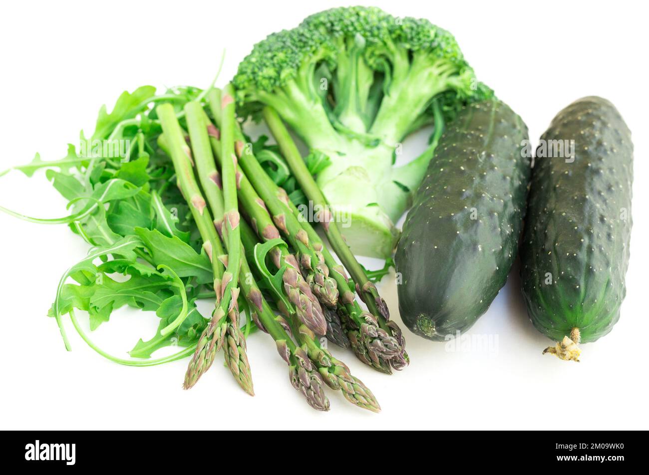 Stillleben von grünem Bauerngemüse, Rucola, Brokkoli, Spargel und Gurken auf weißem Hintergrund Stockfoto