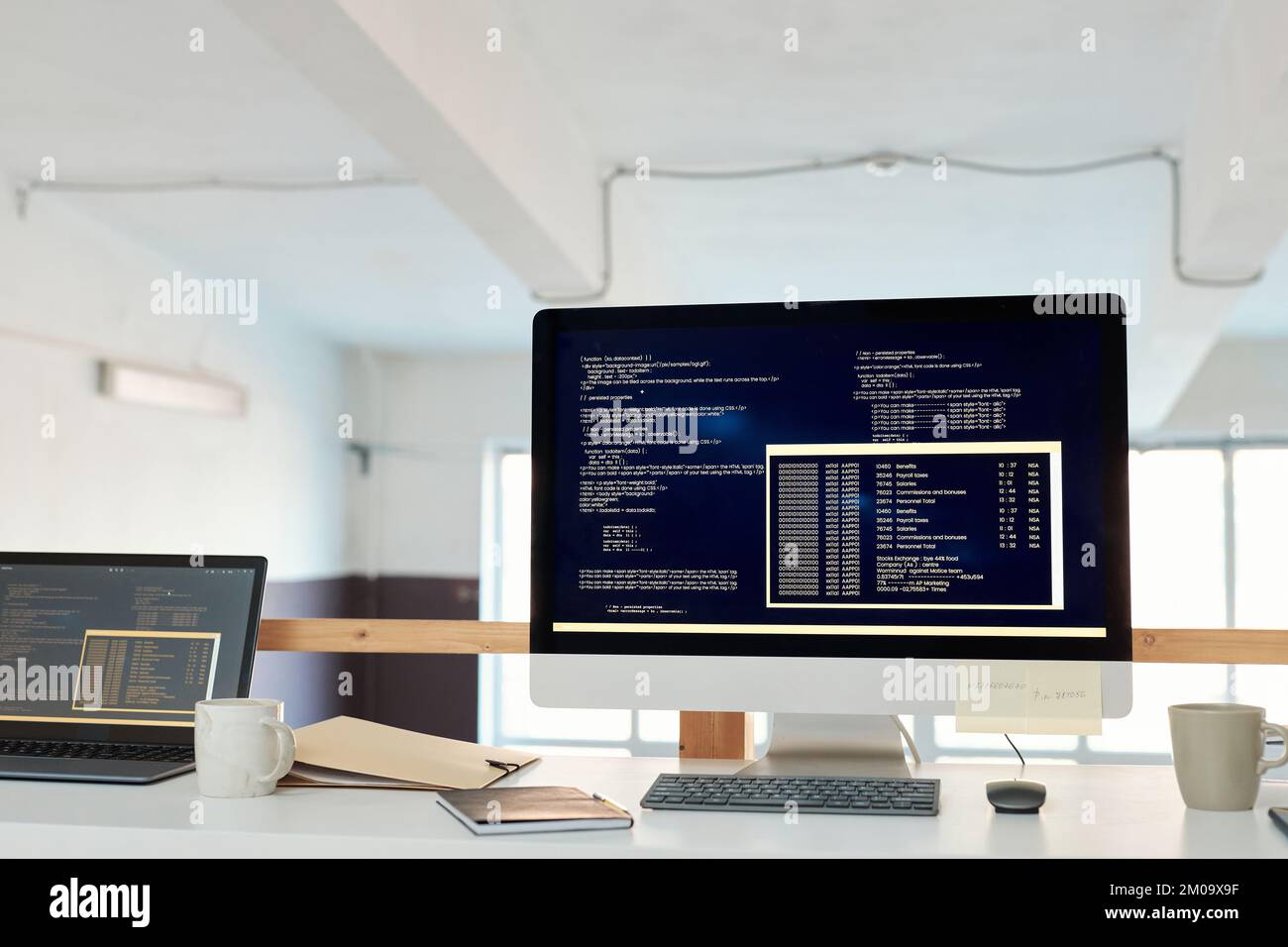 Computer mit Programmiercode auf dem Bildschirm auf dem Schreibtisch des Software-Entwicklers Stockfoto
