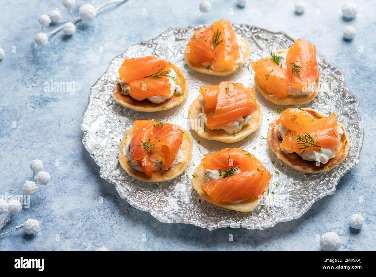 Blini mit geräuchertem Lachs und saurer Sahne, garniert mit Dill ...
