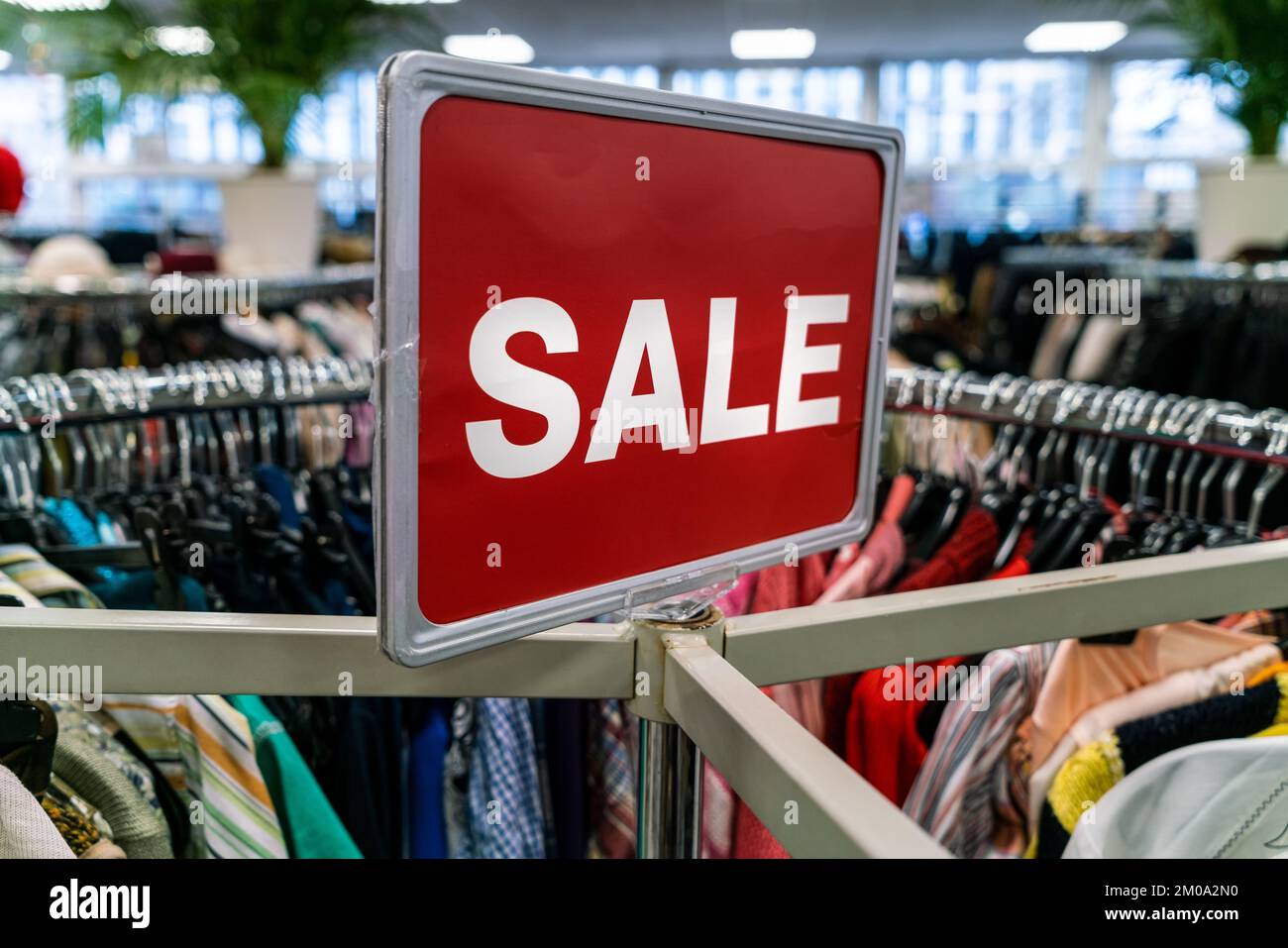 Rotes Verkaufsschild auf Kleiderstange in einem Geschäft oder Geschäft Stockfoto