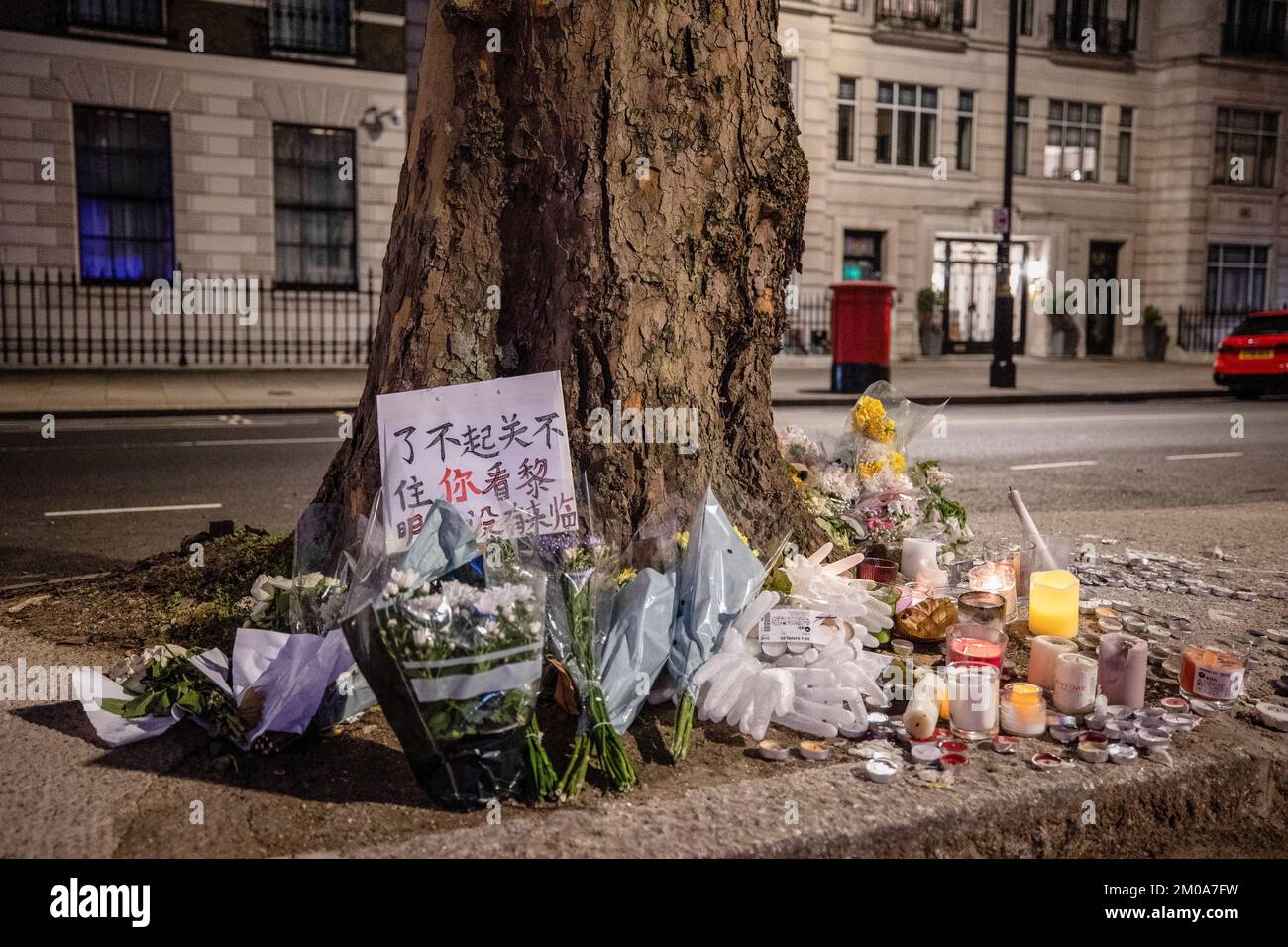 Blumen und Kerzen wurden in der Wache in Erinnerung an die Tragödie gesehen, in der letzte Woche in Urumqi 10 Menschen aufgrund der COVID-Lockdown-Politik in China während der Demonstration vor der chinesischen Botschaft in London getötet wurden. Chinesische Studenten, die derzeit in London studieren, versammelten sich bei der chinesischen Botschaft in London, um gegen die Lockdown-Politik in China zu protestieren. Letzte Woche kam es in China zu einer massiven Welle von Protesten, da 10 Menschen in einem Urumqi in der Nordwestregion Chinas aufgrund der unmenschlichen COVID-Lockdown-Politik getötet wurden. (Foto: Hesther Ng/SOPA Images/Sipa USA) Stockfoto