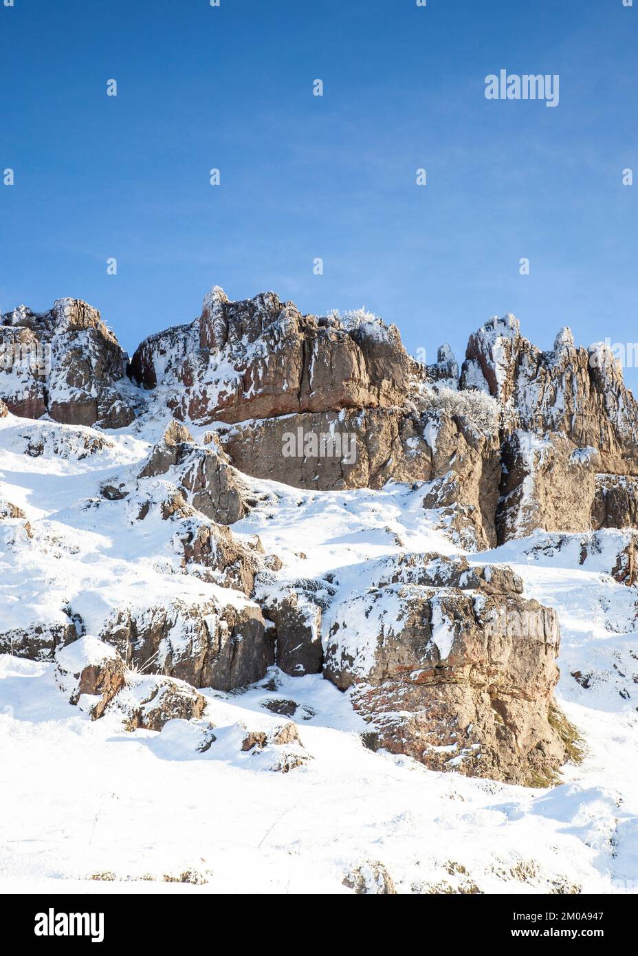 Wintersonne mit blauem Himmel, Schnee und Frost bedeckte Harboro Rocks. Harboro Rocks ist ein Rand aus Magnesiumkalkstein in der Nähe von Brassington, der Felsen bietet Stockfoto