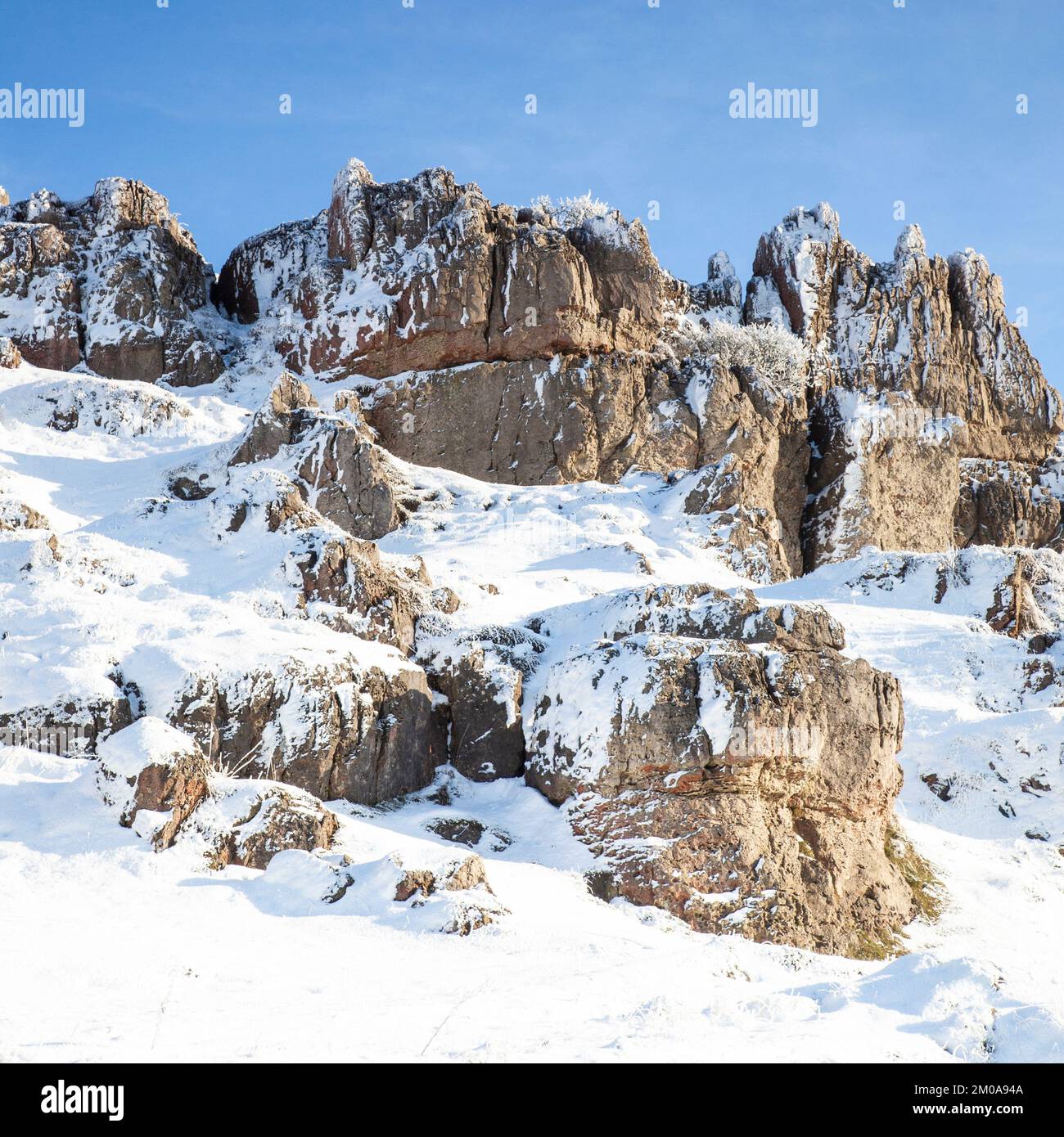 Wintersonne mit blauem Himmel, Schnee und Frost bedeckte Harboro Rocks. Harboro Rocks ist ein Rand aus Magnesiumkalkstein in der Nähe von Brassington, der Felsen bietet Stockfoto