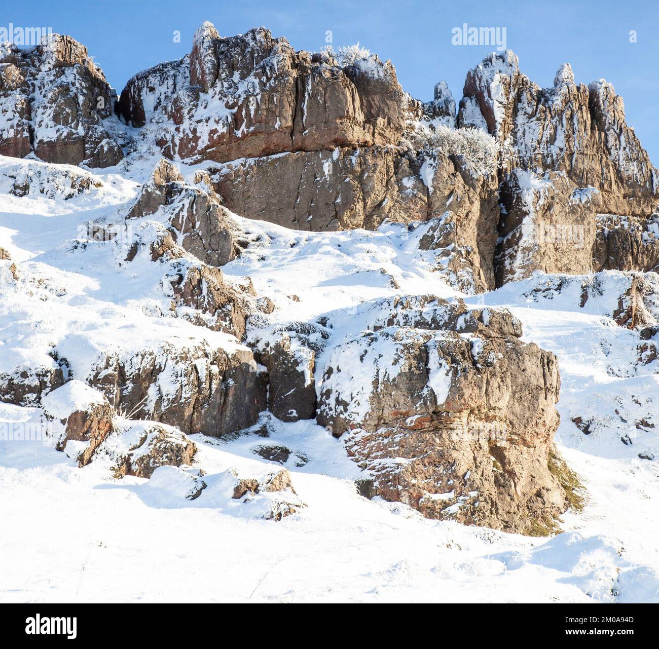 Wintersonne mit blauem Himmel, Schnee und Frost bedeckte Harboro Rocks. Harboro Rocks ist ein Rand aus Magnesiumkalkstein in der Nähe von Brassington, der Felsen bietet Stockfoto