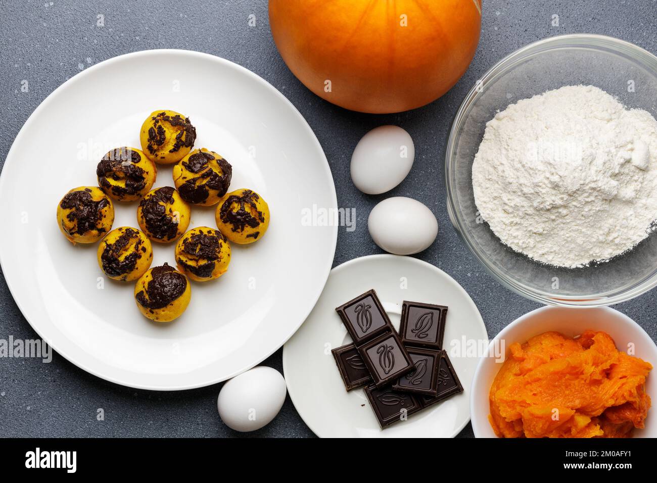 Süße kleine Kürbis-Muffins, serviert am Tisch mit Zutaten. Muffin-Bäckerei mit hausgemachtem Kochhintergrund Stockfoto Süße kleine Kürbis-Muffins, serviert am Tisch mit Zutaten. Muffin-Bäckerei mit hausgemachtem Kochhintergrund Stockfoto