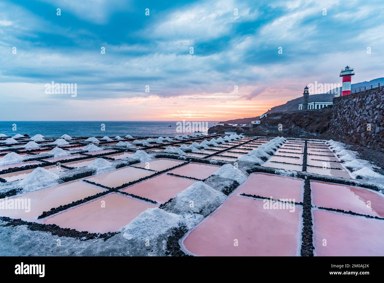 Farbenfrohe Salzbergwerke und Leuchtturm in der Nähe des Ozeans Stockfoto