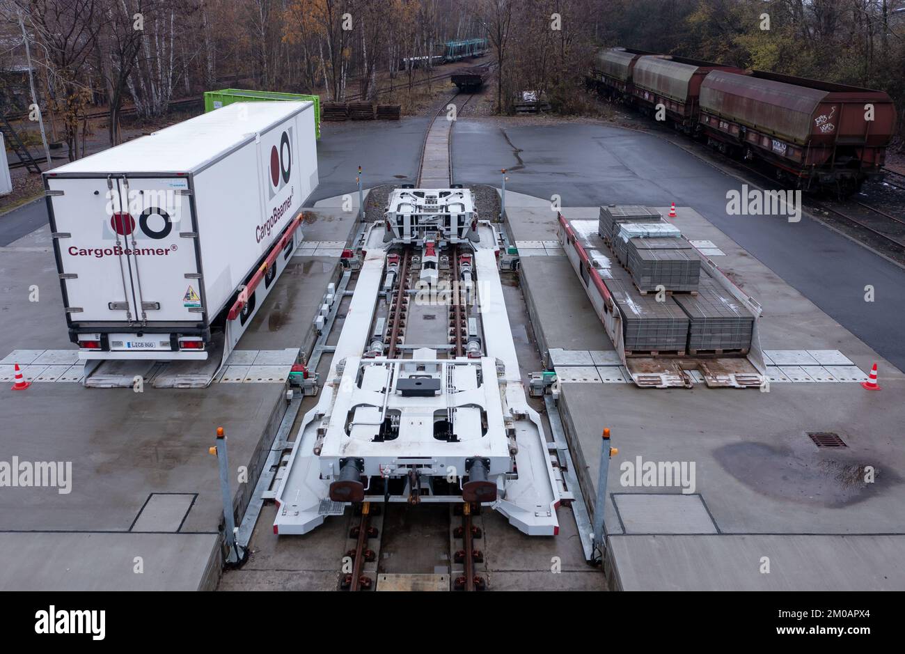 05. Dezember 2022, Sachsen, Leipzig: Ein Auflieger wird an einem Güterbahnhof mit einer neuen Ladetechnik auf einen Eisenbahnwagen verladen. Das Leipziger Unternehmen CargoBeamer möchte den Güterverkehr innerhalb Europas effizienter und umweltfreundlicher gestalten. Im neu entwickelten Terminal können Lkw-Anhänger mit Hilfe einer sogenannten Laderampe seitlich auf den Waggon gefahren werden. Dadurch wird das Problem umgangen, dass fast alle Lkw-Anhänger nicht mit einem Kran angehoben werden können, was die Beladung der Schiene kostspielig und nicht lohnenswert macht. Das erste Terminal des Unternehmens ist in Calais in Nordfrankreich in Betrieb Stockfoto