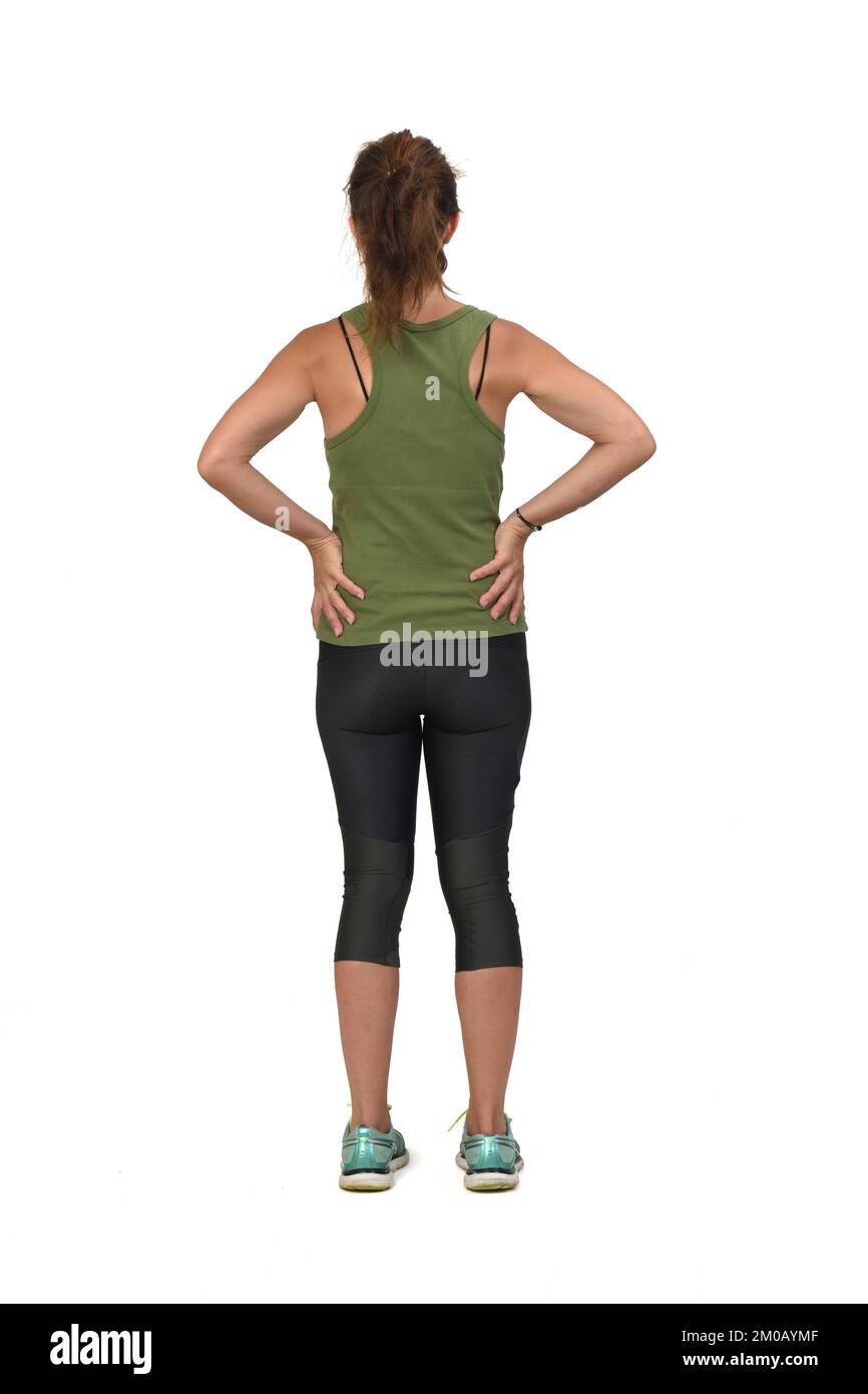 Rückansicht einer Frau mit Sportswear-Händen-Akimbo auf weißem Hintergrund Stockfoto