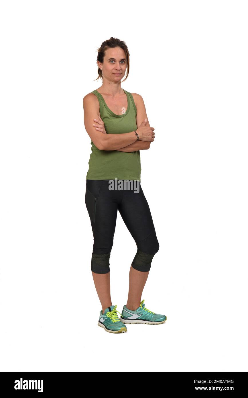 Ansicht einer Frau mit gekreuzten Armen und Blick in die Kamera mit Sportbekleidung auf weißem Hintergrund Stockfoto